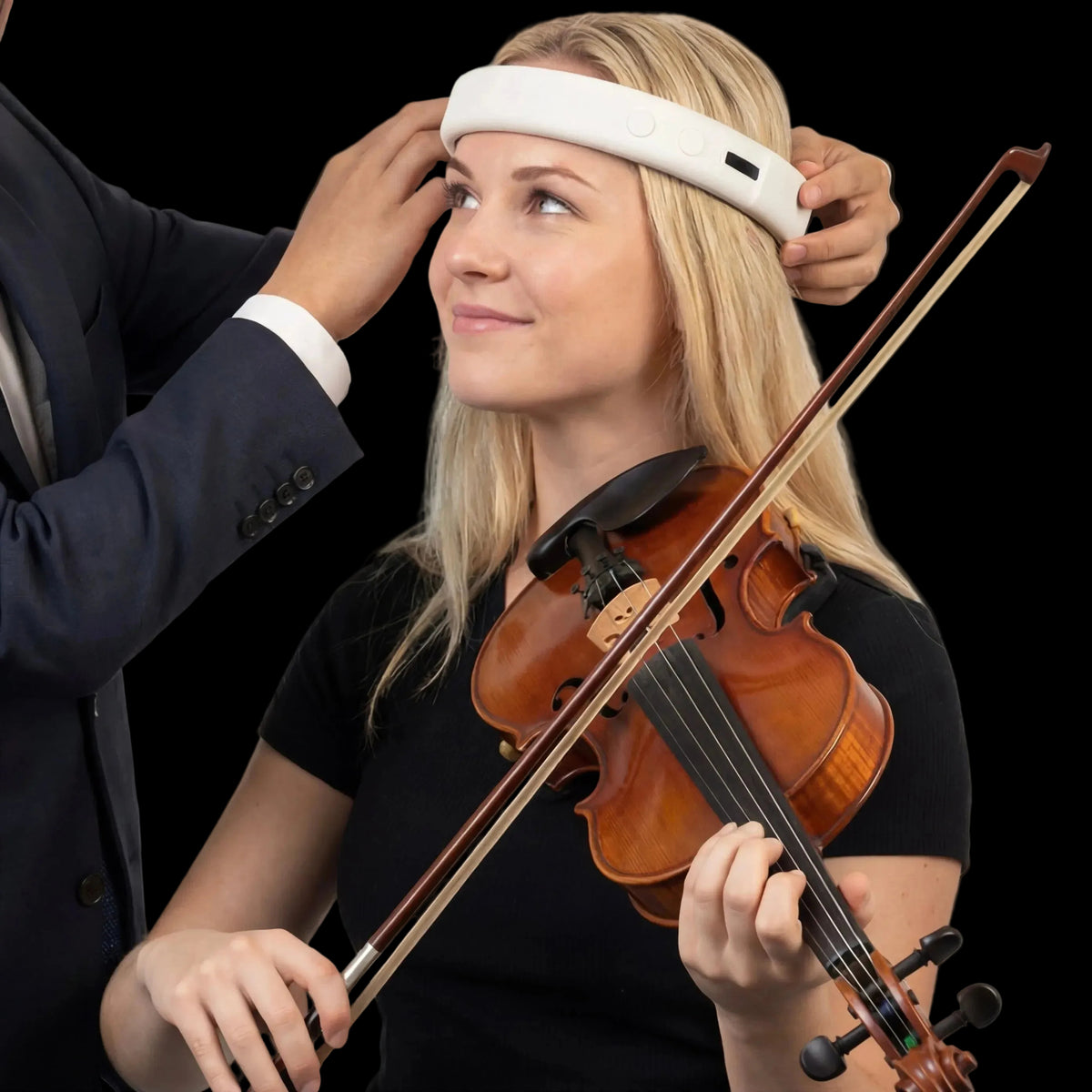 Tony Kim fitting a MetroBand headband on a young musician playing the violin
